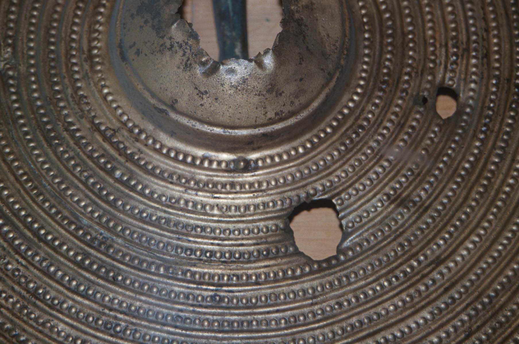 Close up of a shield with 2 holes in it Close up of a shield with 2 holes in it