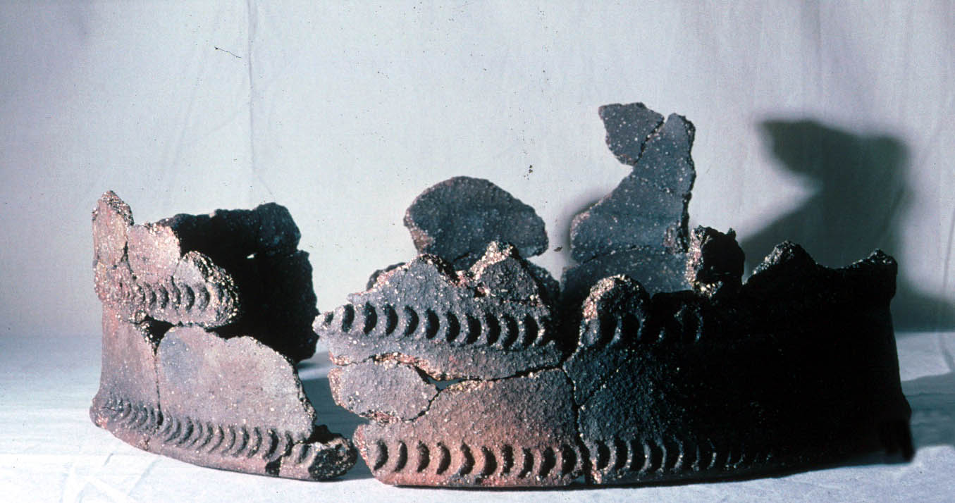 A large rim of a pot with some areas missing A large rim of a pot with some areas missing