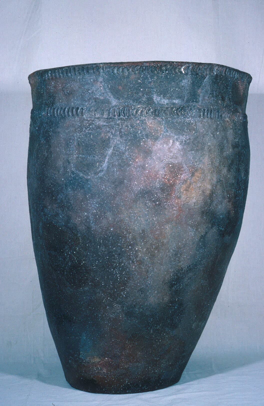 A large pot with an arrow shaped design around the rim A large pot with an arrow shaped design around the rim