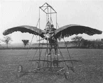 Man standing on framework supporting a winged flying machine.