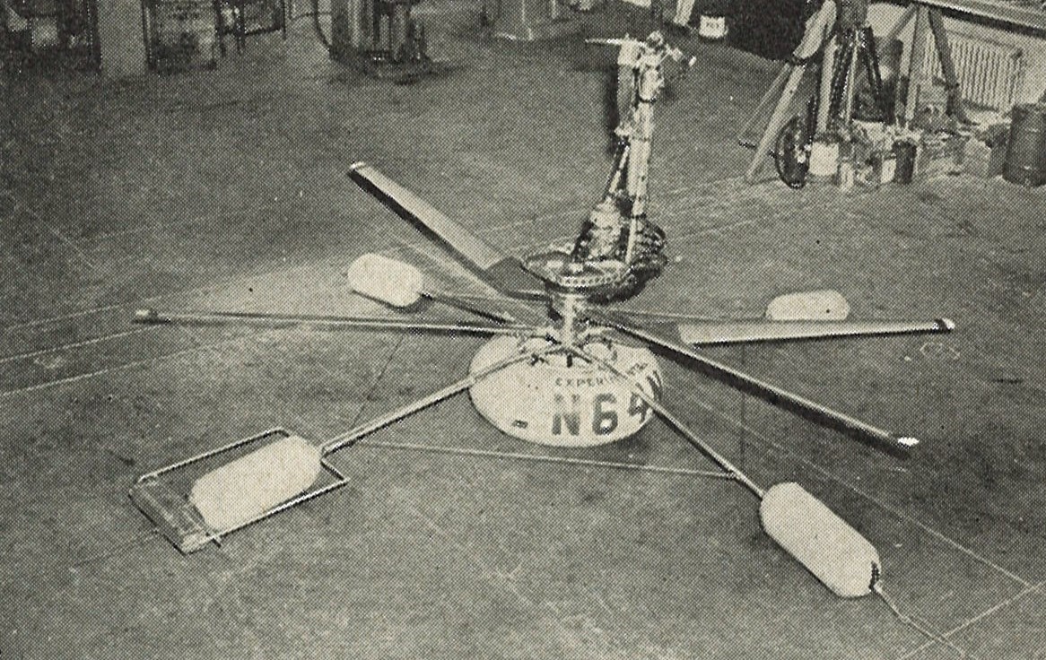 The heli-vector stood on the ground with two sets of rotator blades resting on four padded feet..