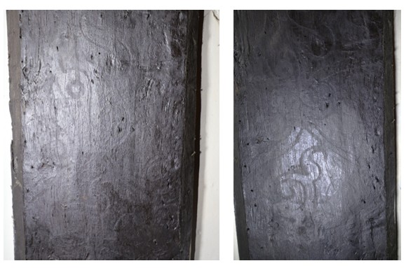 Two panels of dark wood with carved patterns on the surfaces