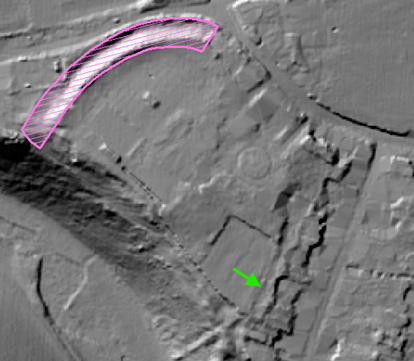 Aerial image in grey showing features of various shapes, depths and sizes etc. Pink hatched semi-circle drawn towards top left of open ground. Green arrow pointing to strongly defined linear feature.