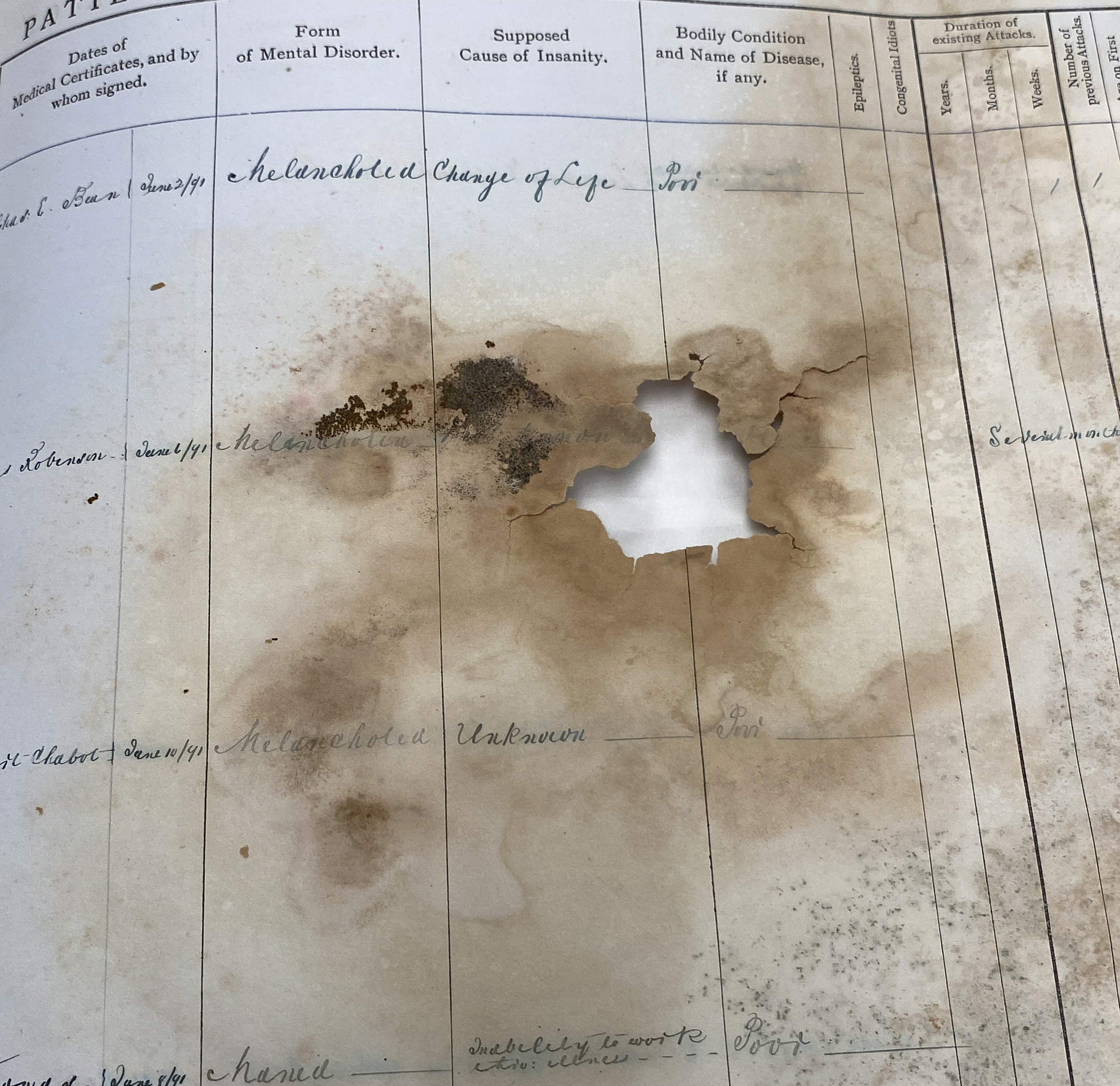 Page with manuscript text in printed grid, with hole in page, flaking paper and browning