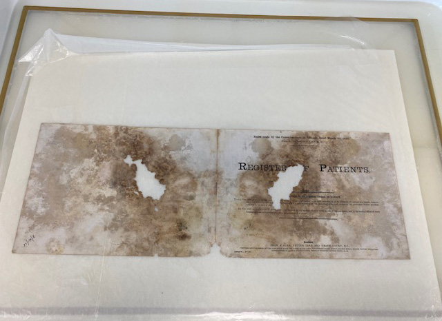 Double printed page sat on beige paper background with clear covering laid over. 