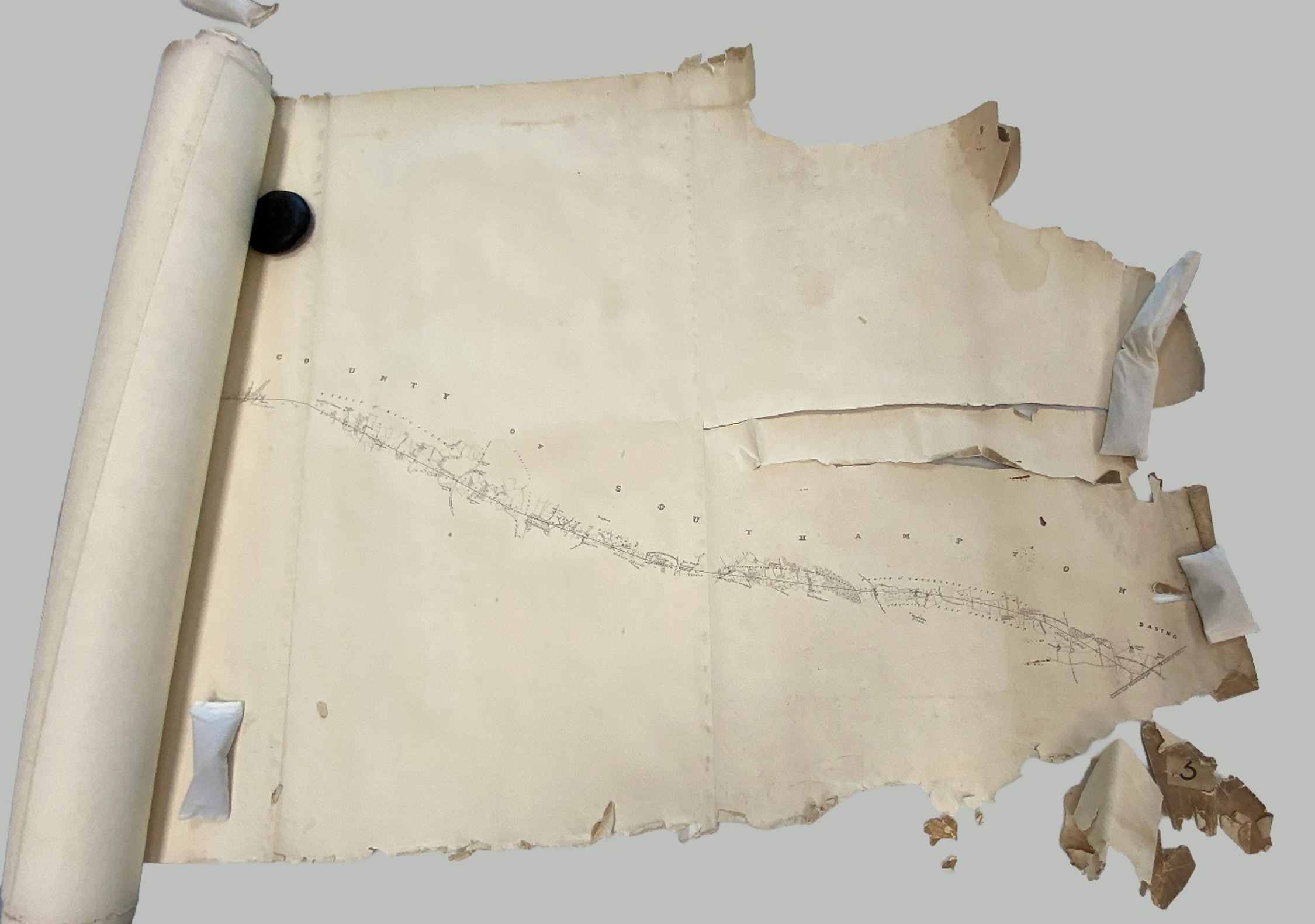 End of long paper map with torn and fragmented paper 